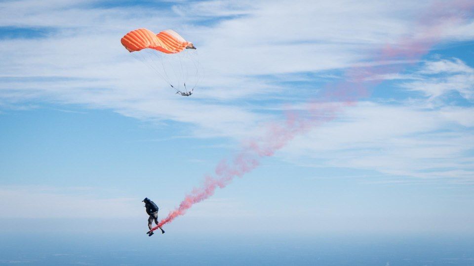 Skydiver cutting away parachute canopy